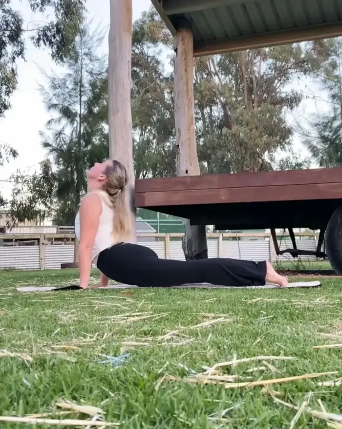 Pilates teacher doing a pose on the grass at 11 Acre Farm