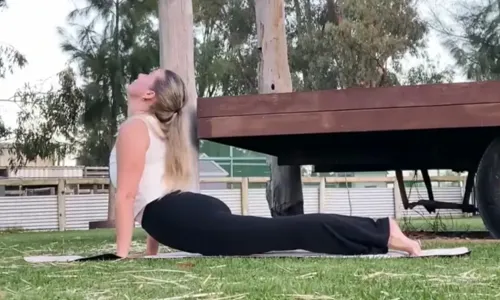 Pilates teacher doing a pose on the grass at 11 Acre Farm