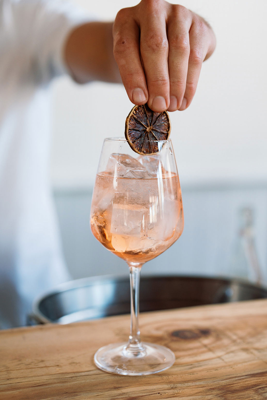 Male hand adding a garnish to a cocktail