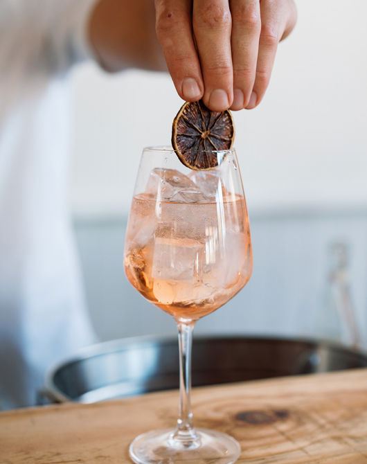 Male hand adding a garnish to a cocktail